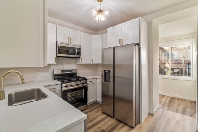1018 North Harding Avenue Chicago, IL 60651 - Photo 6 of 38 a kitchen with stainless steel appliances a refrigerator a stove a sink and a hard wood floors