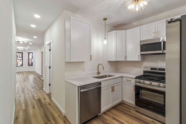 1018 North Harding Avenue Chicago, IL 60651 - Photo 9 of 38 a kitchen with stainless steel appliances a stove cabinets and wooden floor