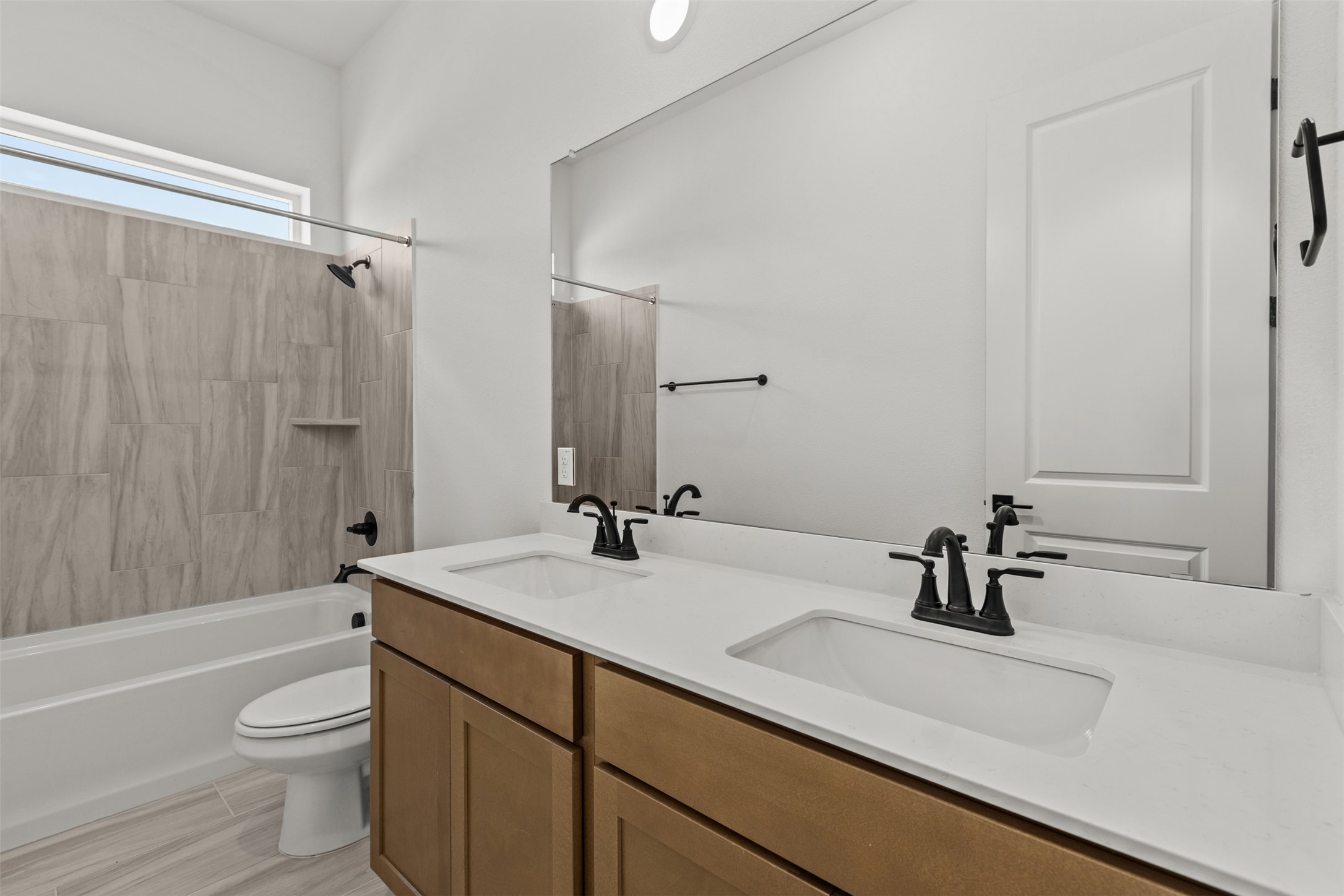 1420 Barth Road Dale, TX 78616 - Photo 23 of 37 Double vanity sinks and an overhead window illuminate this well-appointed bathroom with a tiled shower-tub combination.