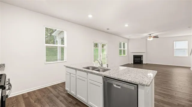 a kitchen with granite countertop cabinets stainless steel appliances and a sink