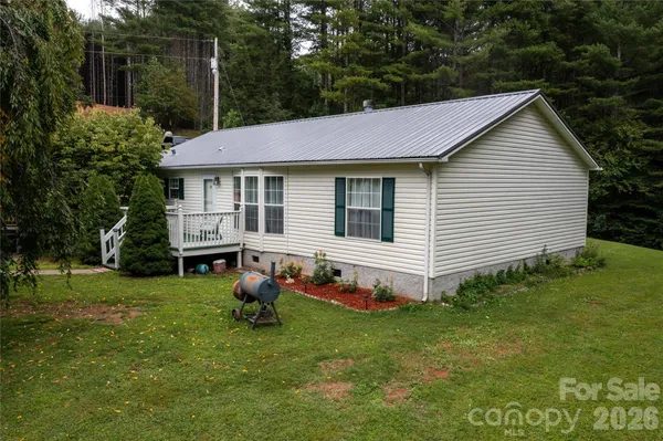 a backyard of a house with potted plants and large tree