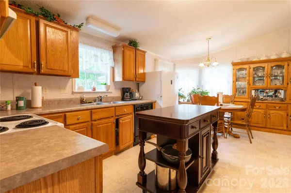 a kitchen with stainless steel appliances granite countertop a stove a sink dishwasher and a refrigerator with wooden cabinets