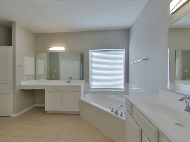 a bathroom with a tub sink and mirror