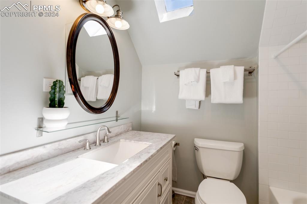 1331 North Tejon Street Colorado Springs, CO 80903 - Photo 35 of 45 a bathroom with a granite countertop toilet a sink and a mirror