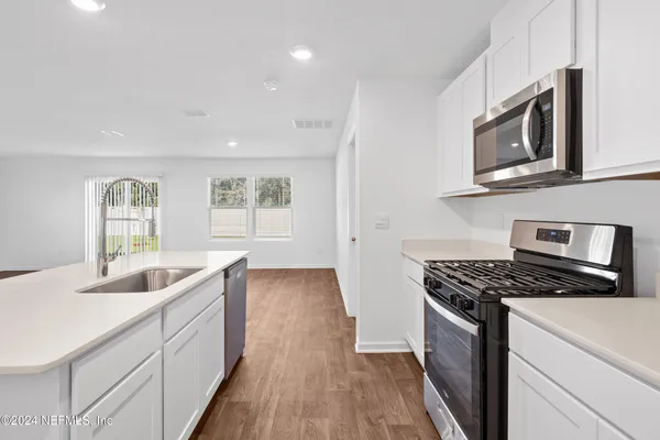 a kitchen with granite countertop a sink and a stove top oven