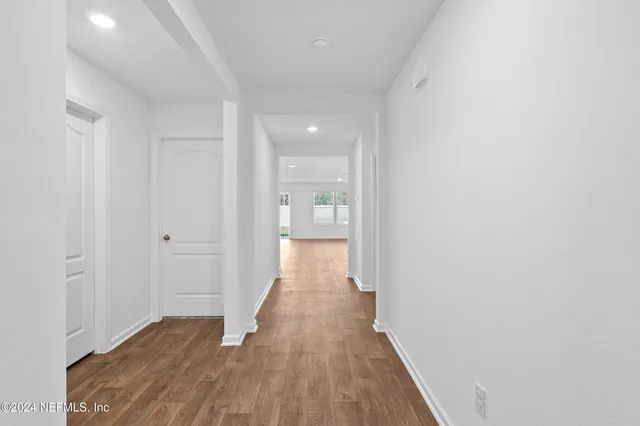 a view of a hallway with wooden floor