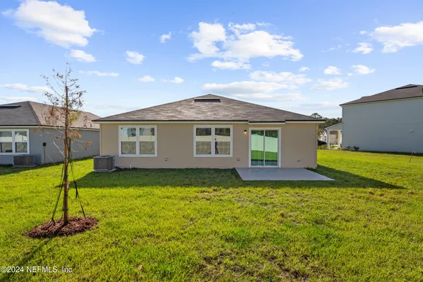 a view of a house with a patio and a yard