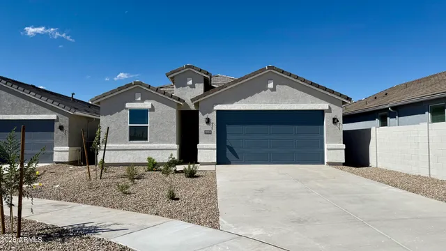 a front view of a house with yard and parking
