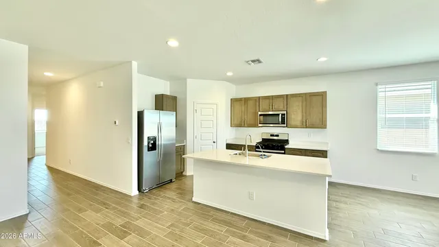 a kitchen with a refrigerator and a stove top oven