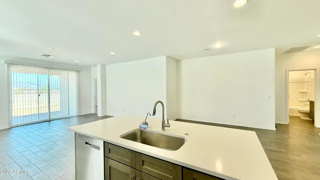 a kitchen with a sink and large refrigerator