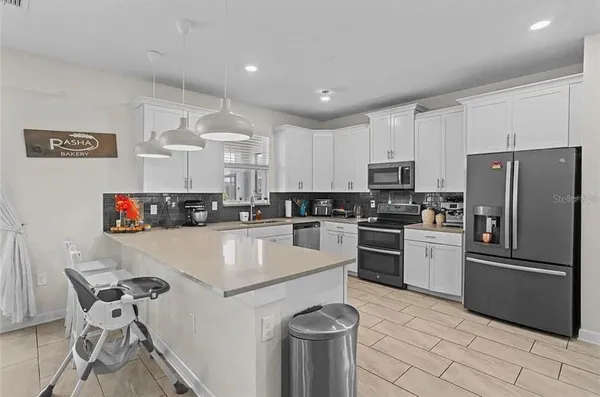 a kitchen with granite countertop white cabinets and stainless steel appliances
