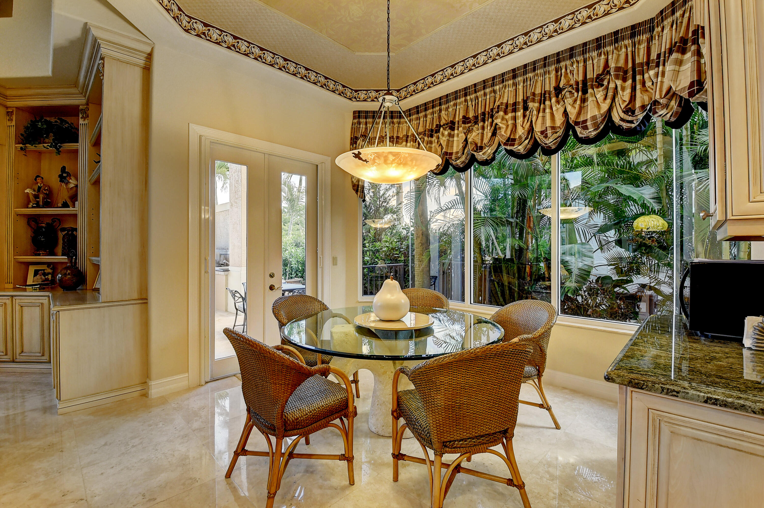 3811 Northwest Coventry Lane Boca Raton, FL 33496 - Photo 11 of 52 a dining room with wooden floor a chandelier a glass table and chairs