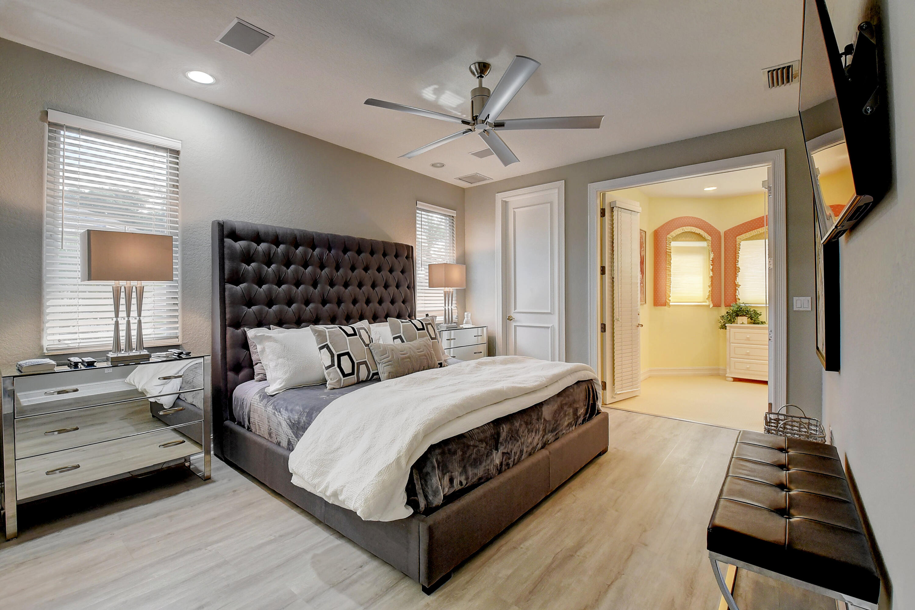 3811 Northwest Coventry Lane Boca Raton, FL 33496 - Photo 26 of 52 a bedroom with a large bed and a chandelier