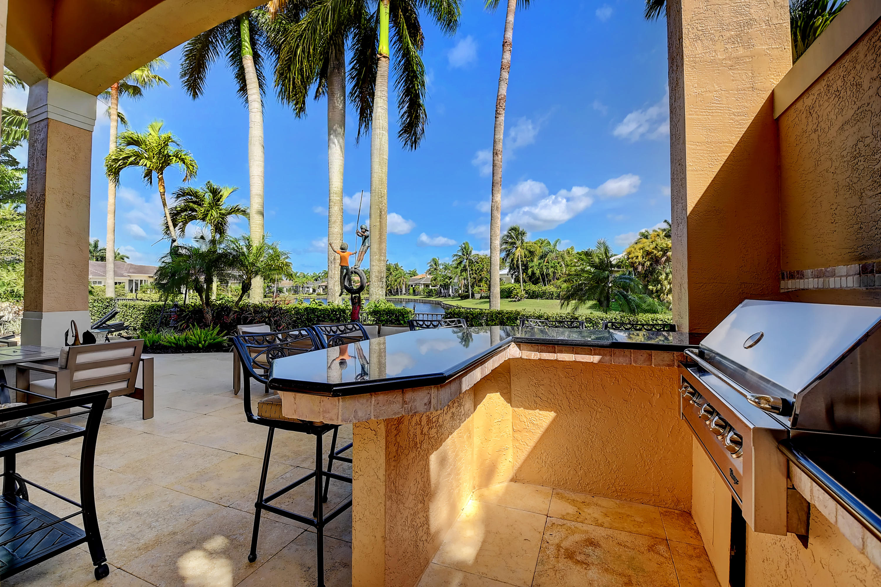 3811 Northwest Coventry Lane Boca Raton, FL 33496 - Photo 33 of 52 a view of a swimming pool with a table and chairs