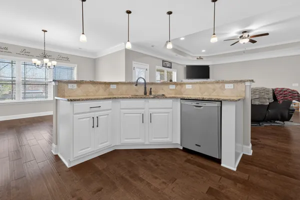 a kitchen with a sink a counter space and wooden floor