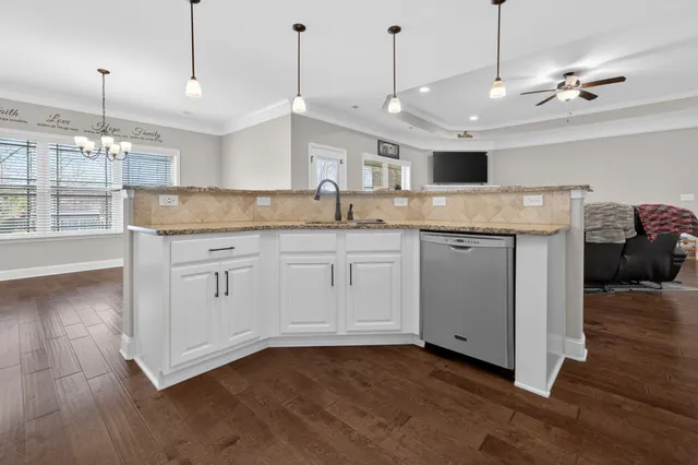 a kitchen with a sink a counter space and wooden floor