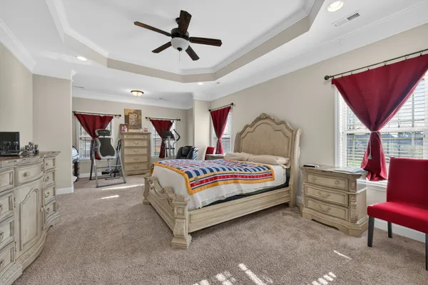 a bedroom with a large bed and a chandelier