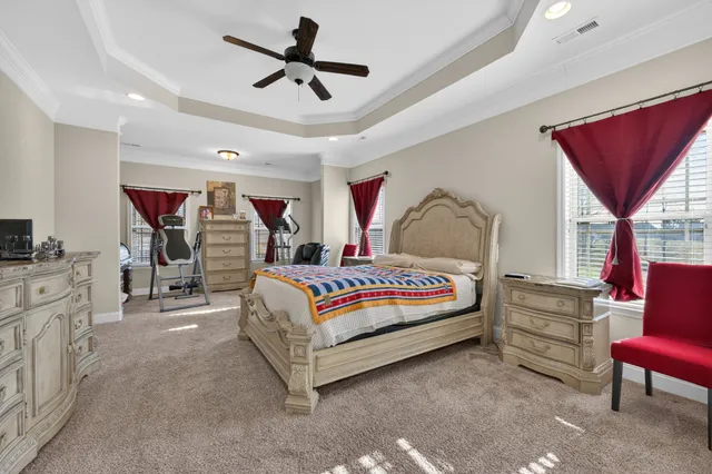 a bedroom with a large bed and a chandelier