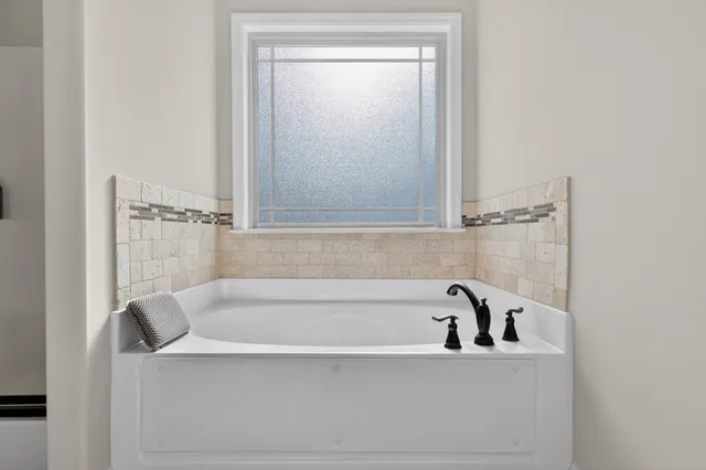 a white bath tub sitting next to a shower