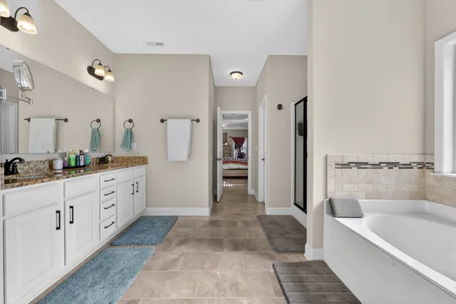 a bathroom with a tub a sink and a shower