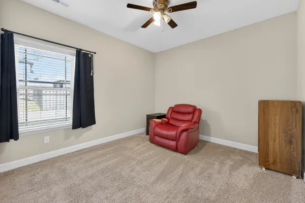 a view of a room with a cabinet and a ceiling fan