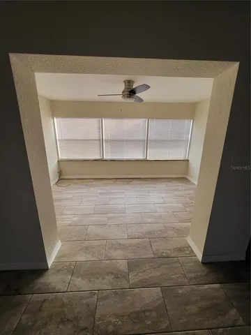 a view of a refrigerator in kitchen and an empty room