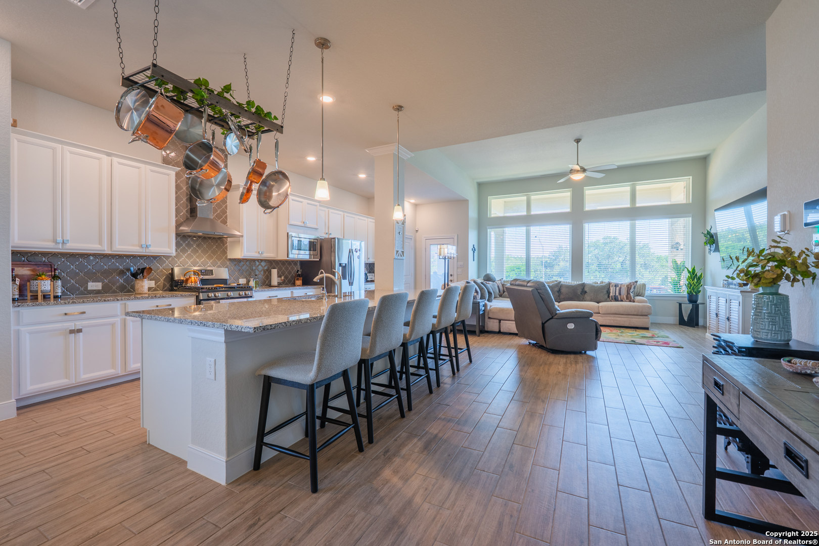 22842 Rio Salado San Antonio, TX 78261 - Photo 6 of 41 a kitchen with stainless steel appliances granite countertop wooden floors stove dining table and chairs