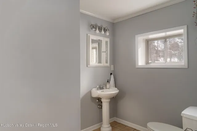 a bathroom with a sink a toilet and mirror