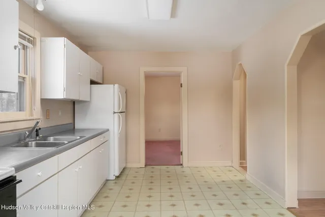 a kitchen with granite countertop a refrigerator and a sink