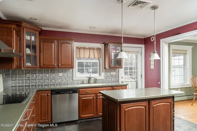 a kitchen with kitchen island granite countertop a sink a counter top space and stainless steel appliances