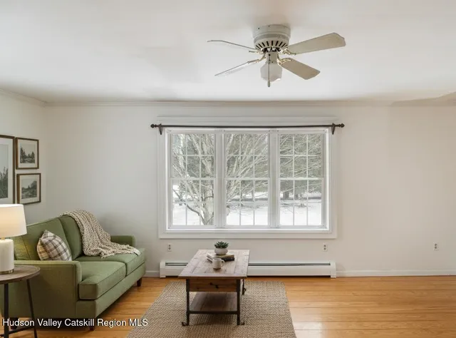 a living room with furniture and a large window with wooden floor