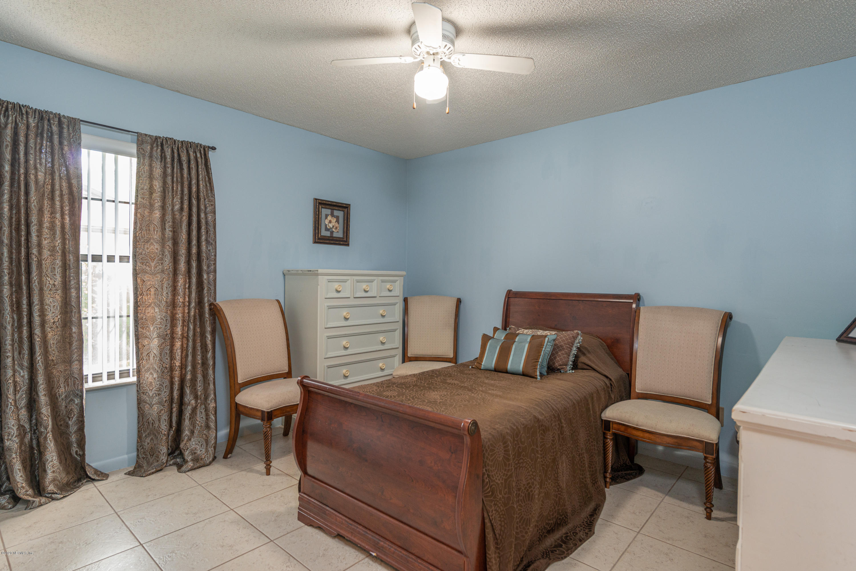 242 Jasmine Road St. Augustine, FL 32086 - Photo 15 of 26 a bedroom with a bed and a chandelier