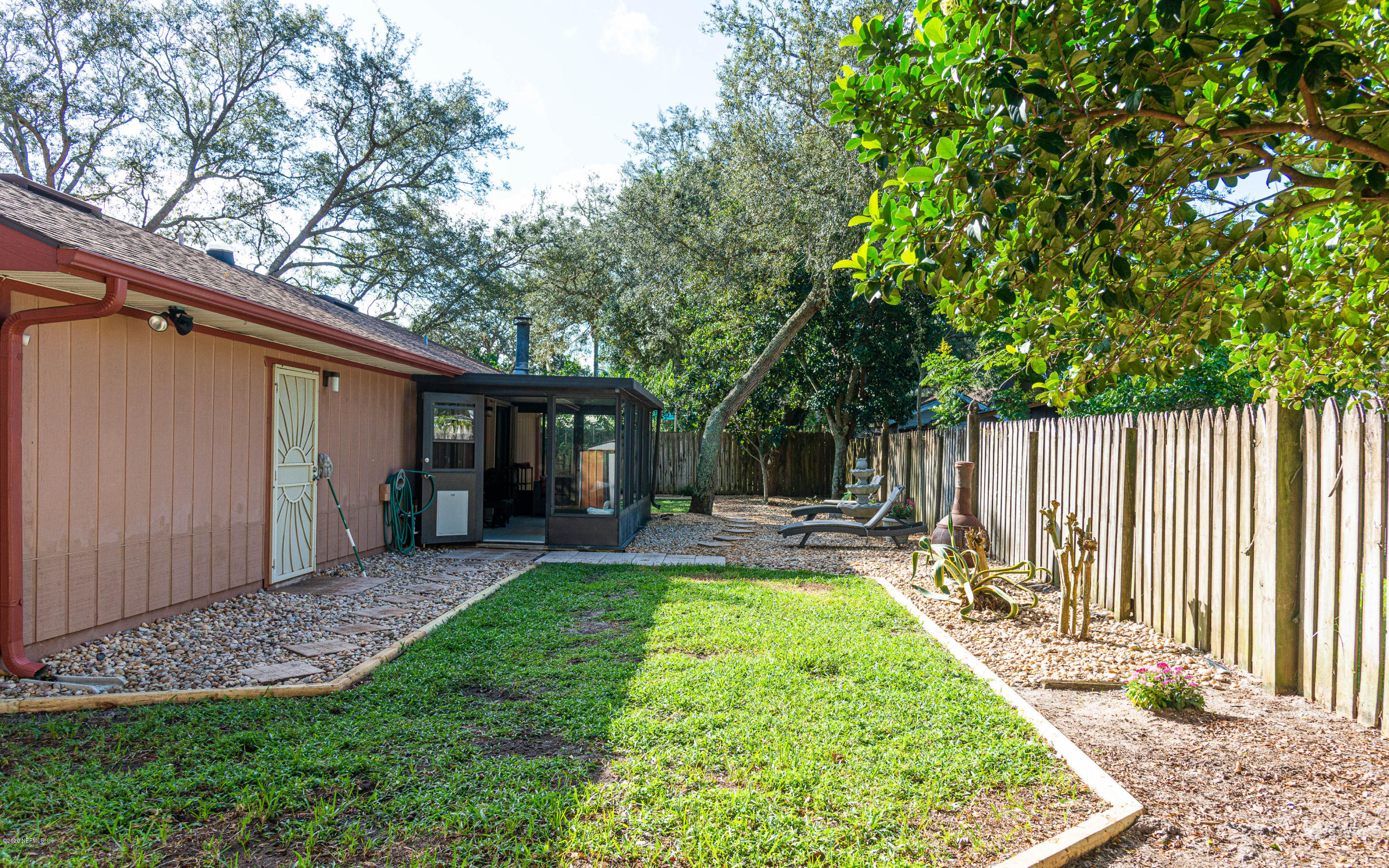 242 Jasmine Road St. Augustine, FL 32086 - Photo 22 of 26 a view of a backyard with table and chairs and wooden fence