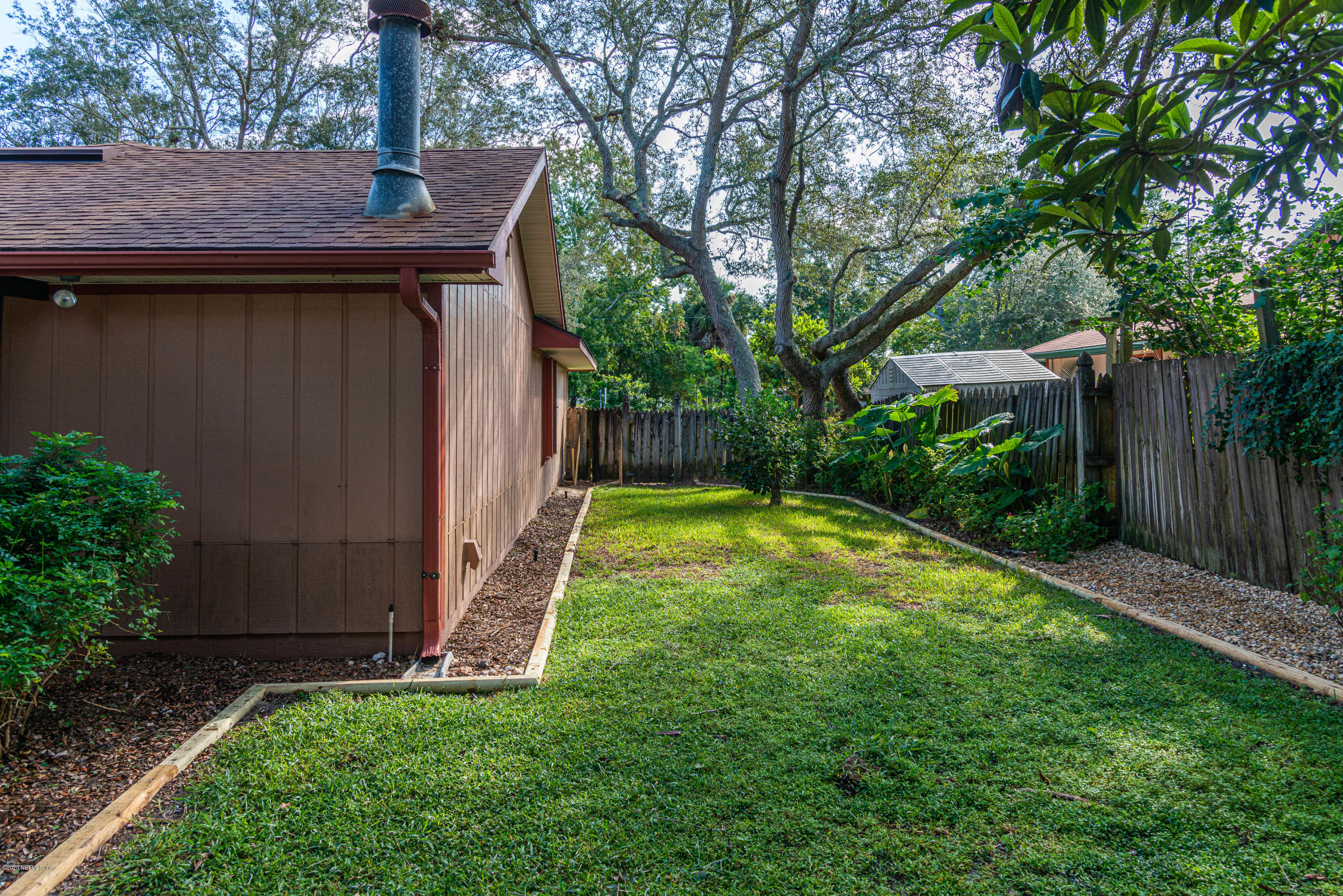 242 Jasmine Road St. Augustine, FL 32086 - Photo 23 of 26 a view of a backyard with a small cabin and wooden fence