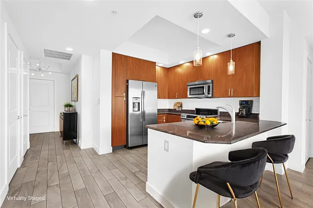 a kitchen with stainless steel appliances granite countertop a sink a stove and a wooden floors