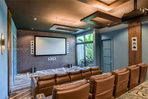 a media room with furniture a rug and a chandelier