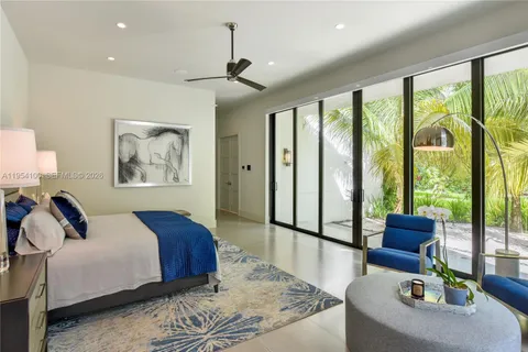 a bedroom with a bed couch and painting on the wall