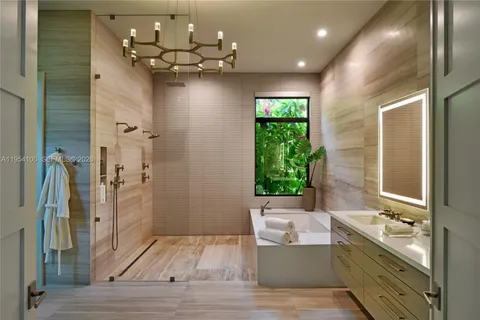 a bathroom with a bathtub a shower a sink and a large mirror