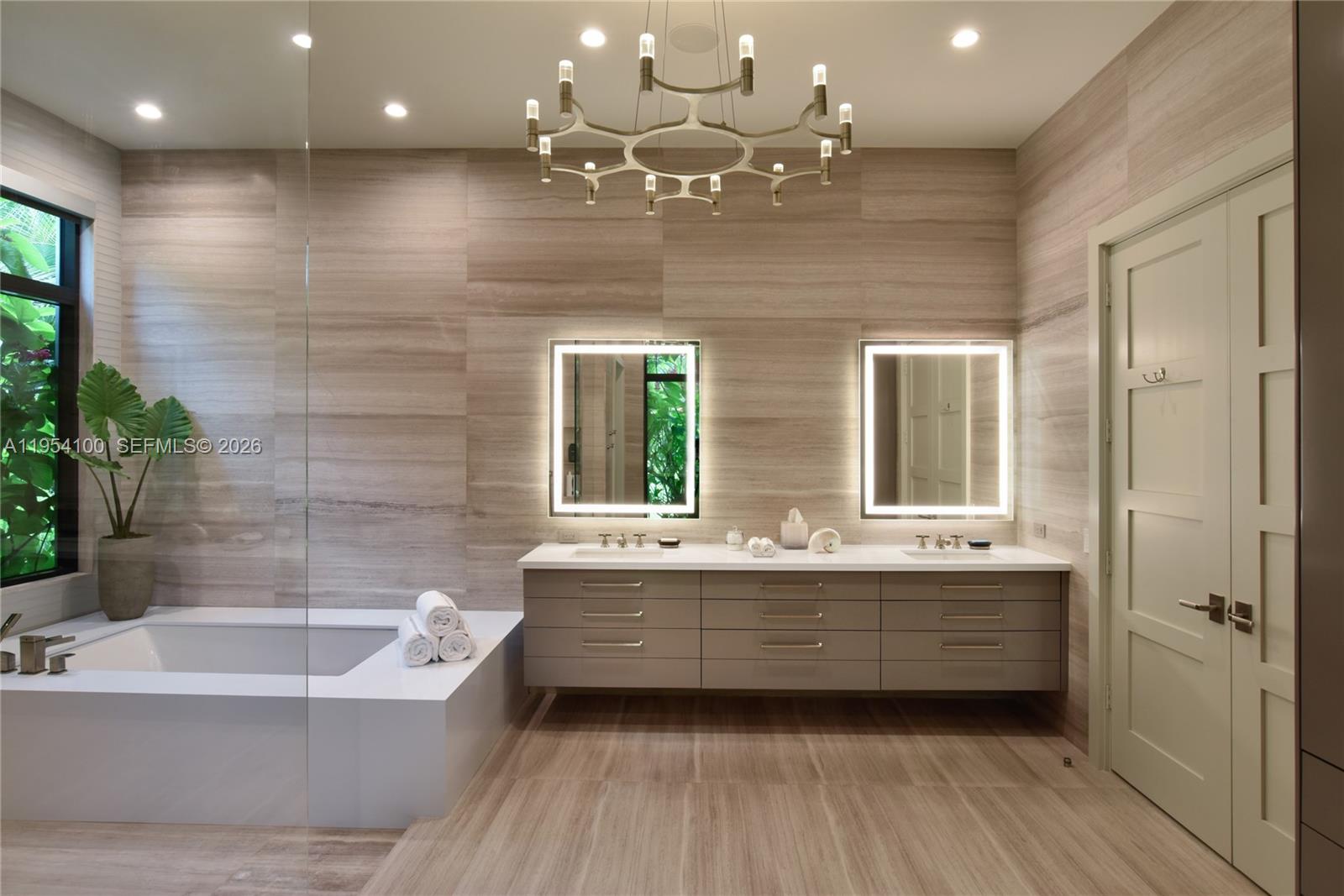 11050 Southwest 69th Avenue Pinecrest, FL 33156 - Photo 25 of 31 a bathroom with a bathtub a shower a sink and a large mirror