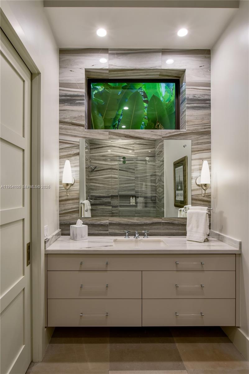 11050 Southwest 69th Avenue Pinecrest, FL 33156 - Photo 27 of 31 a bathroom with a sink and a large mirror