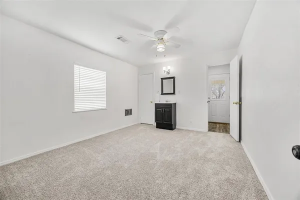 an empty room with windows and fireplace