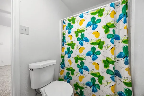 a white painted with a toilet and a shower curtain