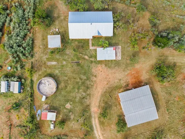 an aerial view of a house with a yard and trees