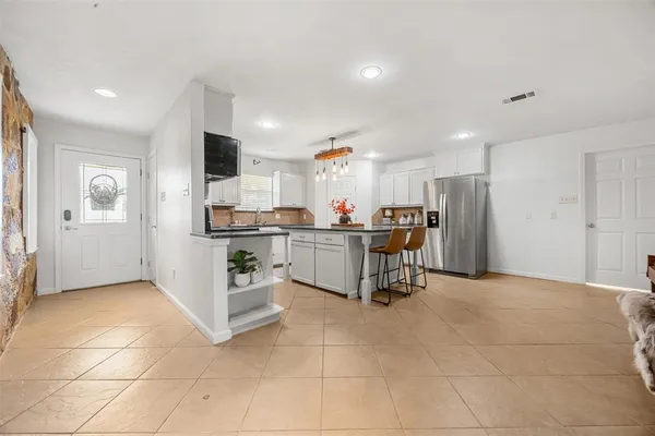 a kitchen with stainless steel appliances kitchen island granite countertop a refrigerator and cabinets