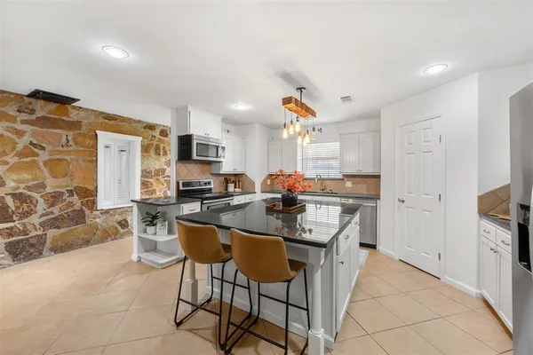 a kitchen with stainless steel appliances kitchen island granite countertop a sink and cabinets