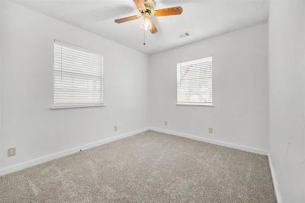 an empty room with a window and a ceiling fan