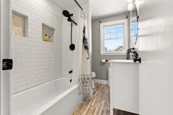 a bathroom with a bathtub a window and a shower