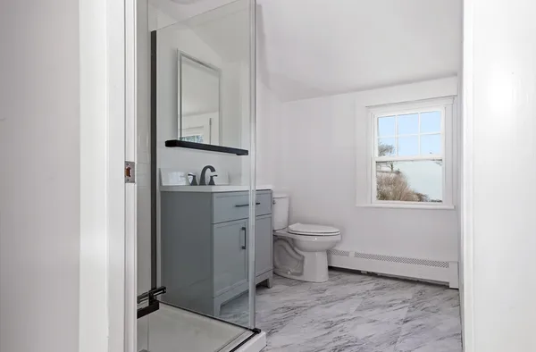 a bathroom with a toilet sink and mirror