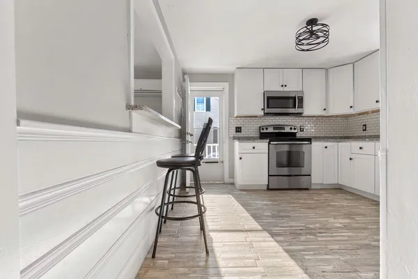a kitchen with granite countertop a stove a sink and a refrigerator