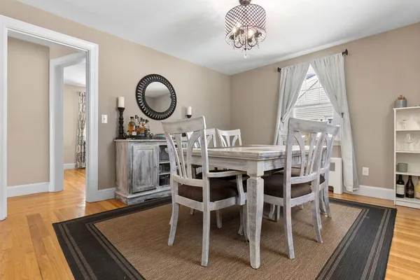 a dining room with furniture a chandelier and wooden floor